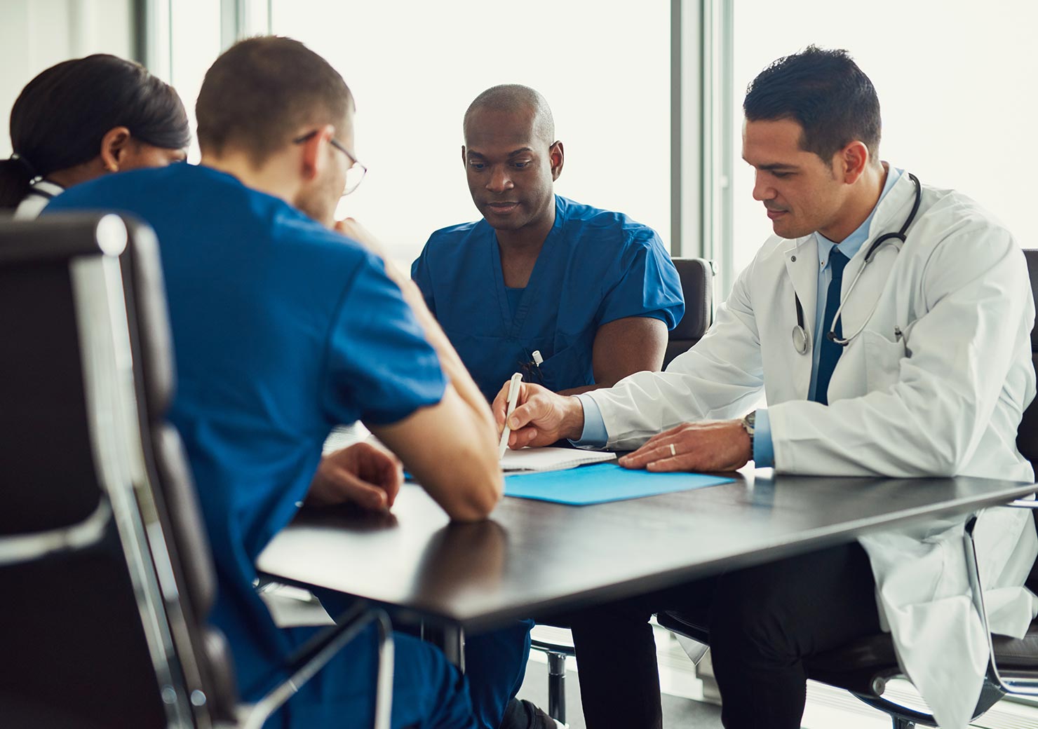 Doctors in discussion at a neurology center, showcasing the professional assessment capabilities of DriveABLE.