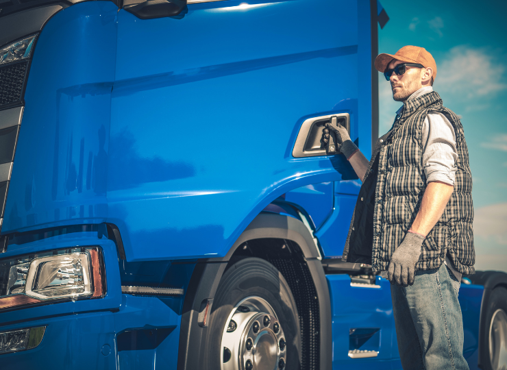 Driver opening door after inspection of a blue truck, ensuring vehicle readiness and safety compliance before hitting the road.