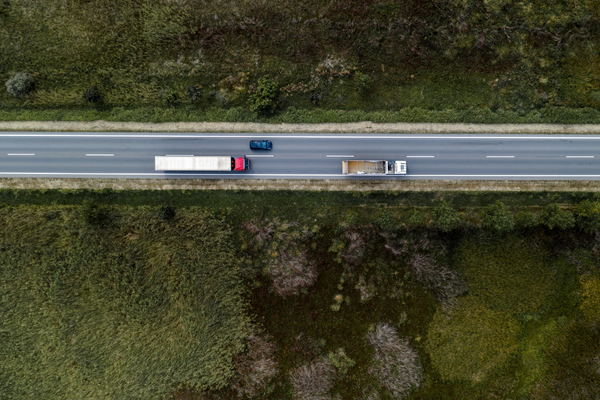 Top-down view of a highway with a truck and car, symbolizing the importance of fleet safety and road monitoring.