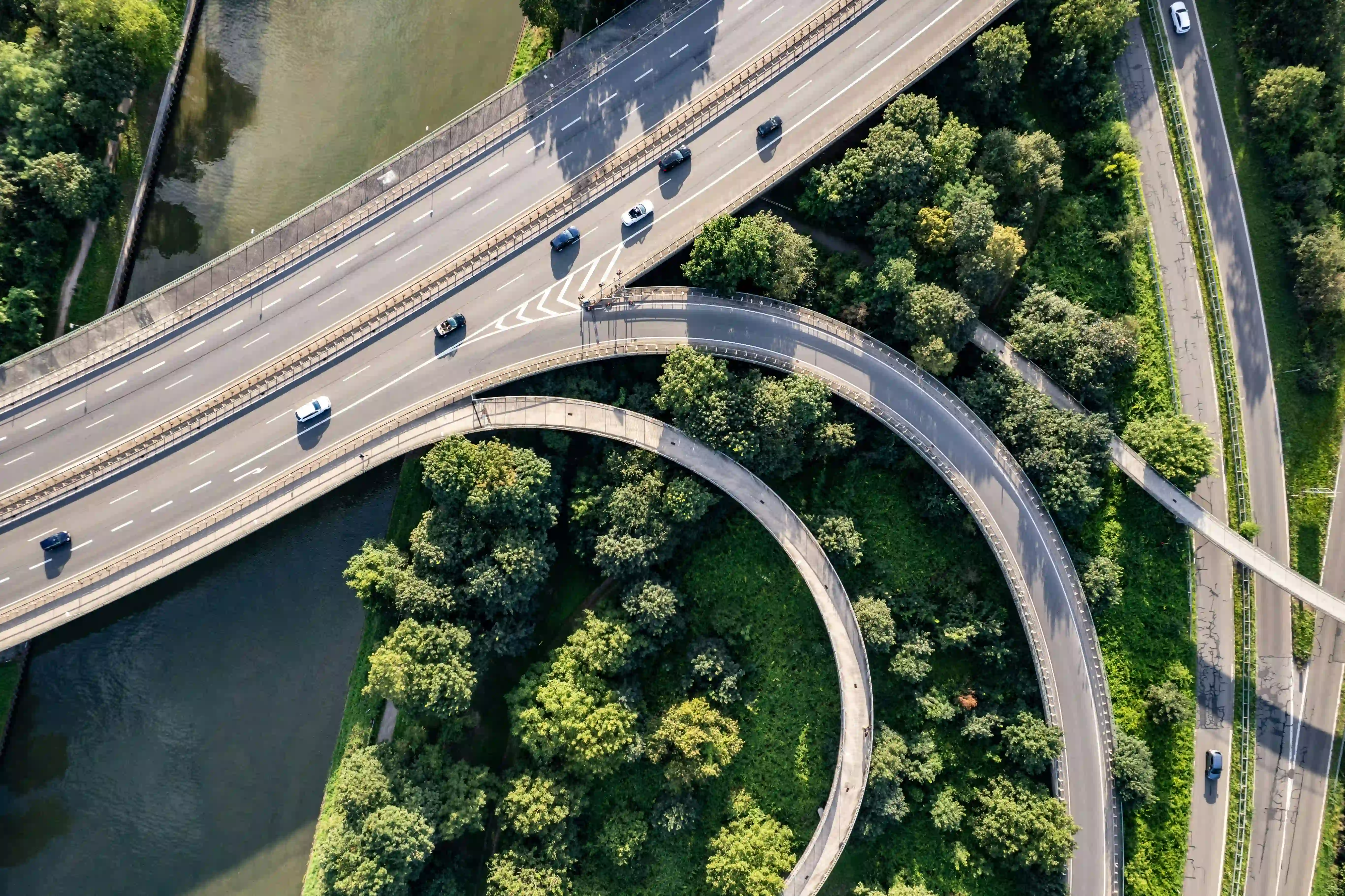 Aerial view of a highway interchange surrounded by greenery and a river.