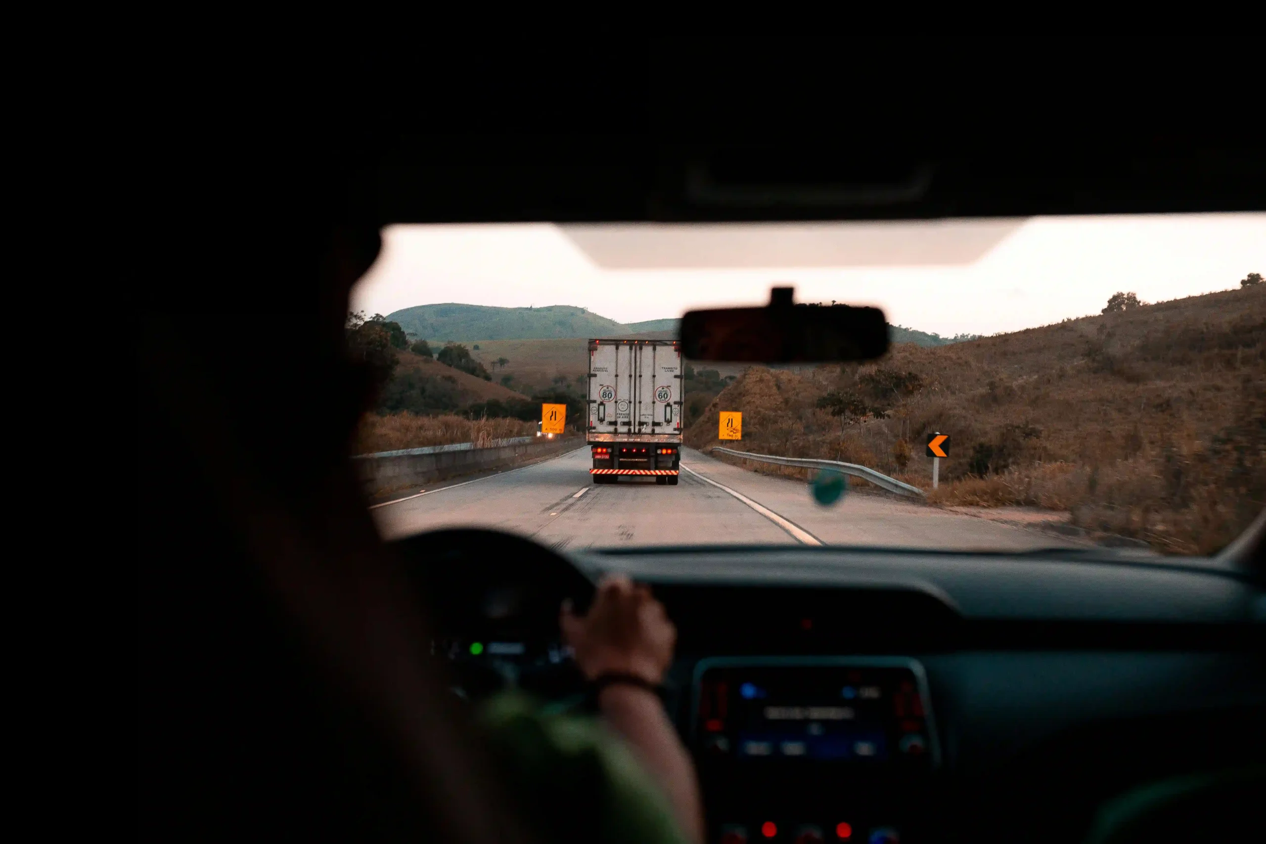 View from inside a car following a truck on the highway.