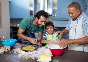 Grandfather, son, and grandson baking together